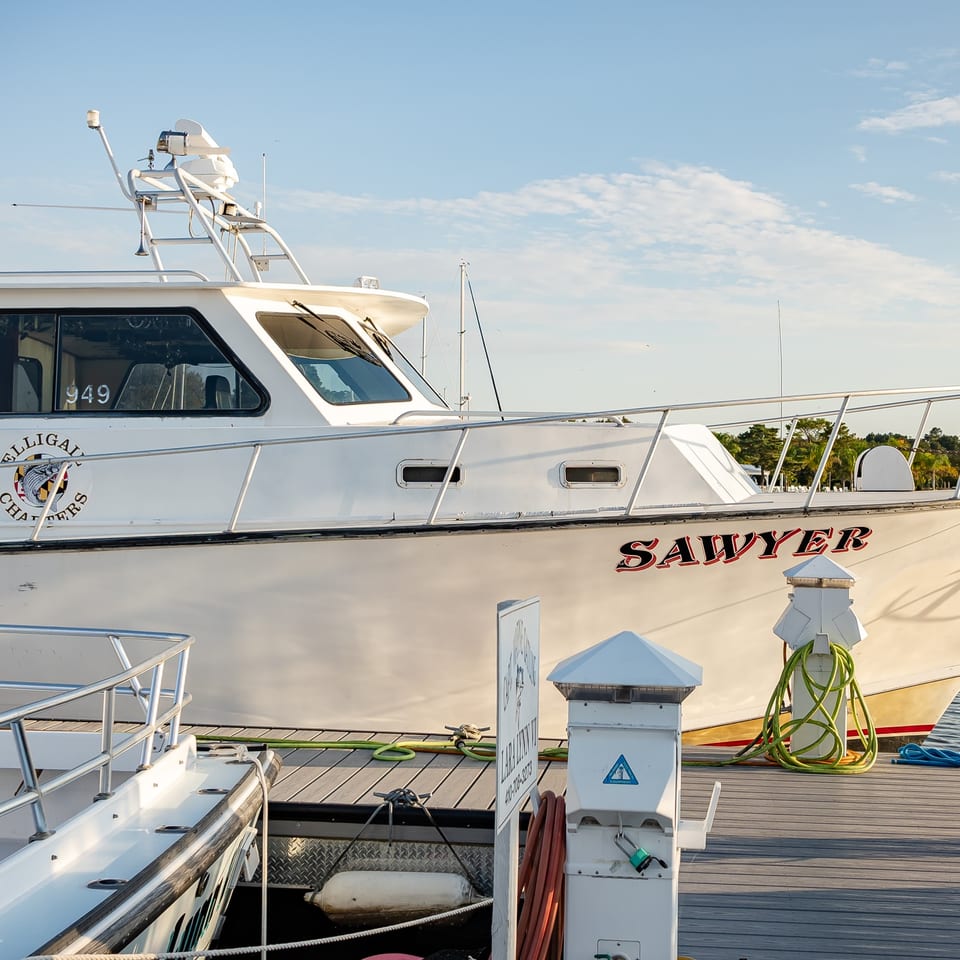 The Sawyer charter boat alongside a dock with utility hookups.