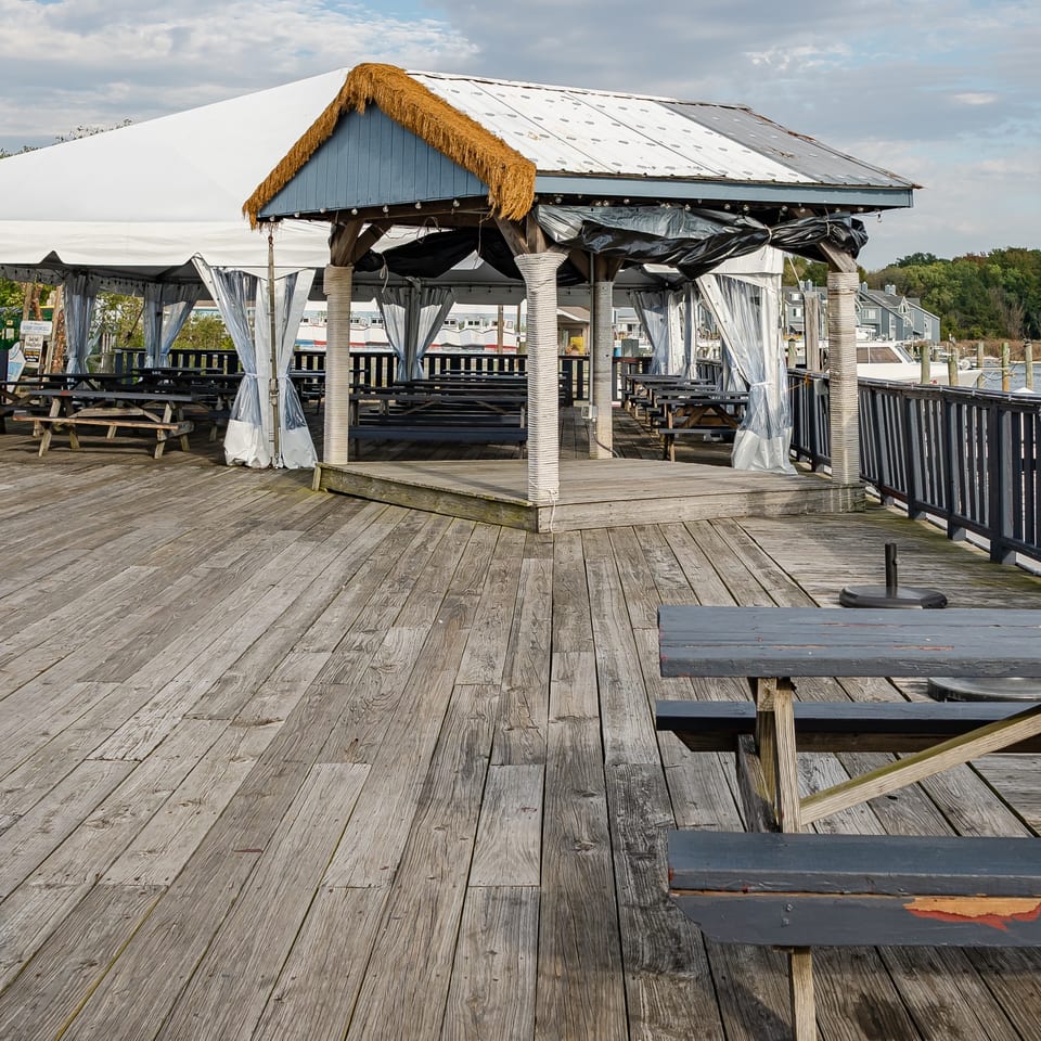 Covered waterfront deck with picnic tables.