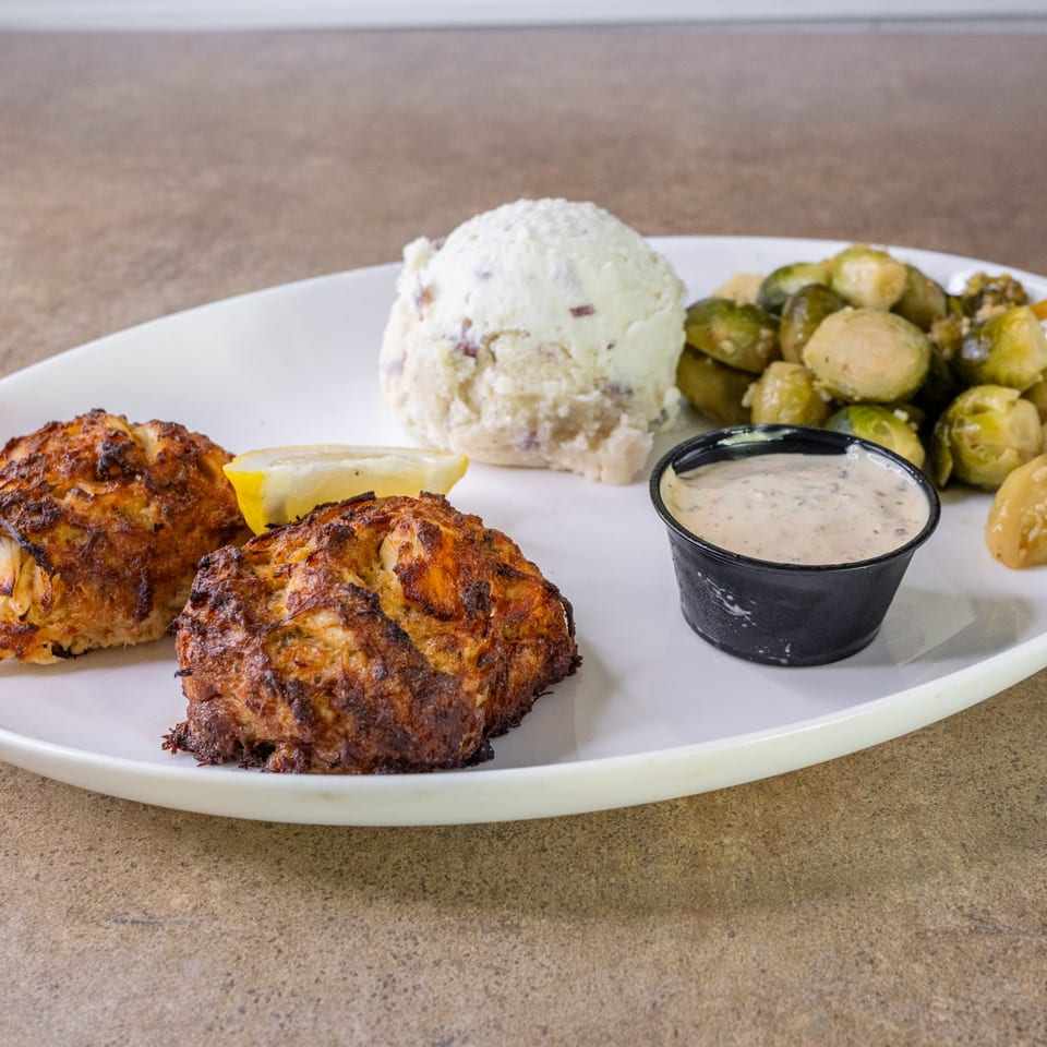Crabcakes with mashed potatoes and vegetables.